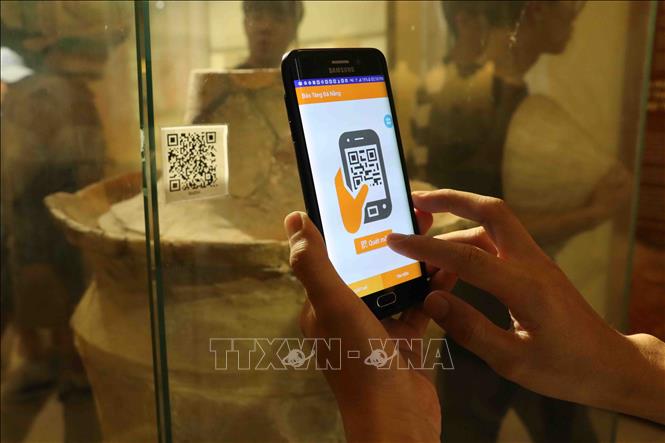Trong ảnh: Sử dụng thiết bị di động để quét mã QR được gắn cho hiện vật để nghe thông tin thuyết minh về hiện vật tại Bảo tàng Đà Nẵng. Ảnh: Trần Lê Lâm - TTXVN