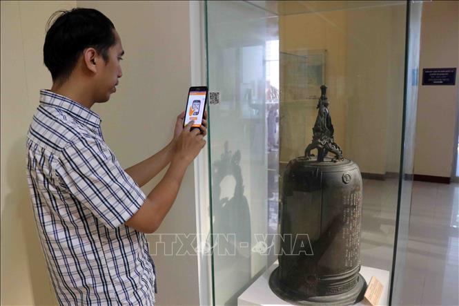 Trong ảnh: Khách tham quan có thể sử dụng thiết bị di động để quét mã QR được gắn cho hiện vật để nghe thông tin thuyết minh về hiện vật tại Bảo tàng Đà Nẵng. Ảnh: Trần Lê Lâm - TTXVN