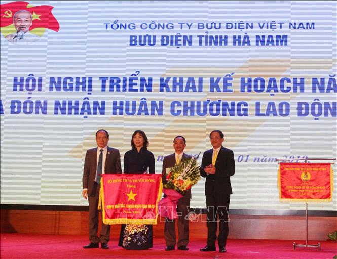 Trong ảnh: Bưu điện tỉnh Hà Nam đón nhận Cờ thi đua xuất sắc của Bộ Thông tin và Truyền thông tặng. Ảnh: Nguyễn Chinh – TTXVN