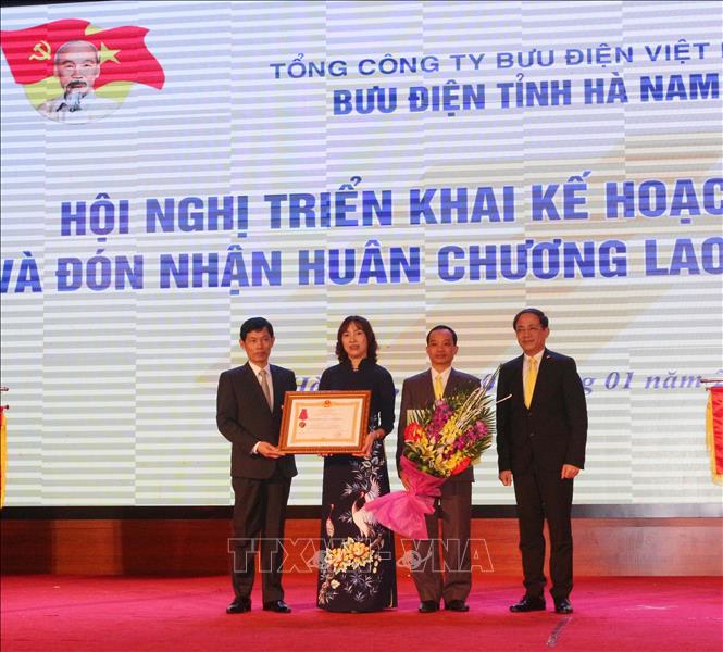 Trong ảnh: Thừa ủy quyền của Chủ tịch nước, ông Bùi Quang Cẩm – Phó chủ tịch UBND tỉnh Hà Nam trao Huân chương Lao động hạng Ba cho Bưu điện tỉnh Hà Nam. Ảnh: Nguyễn Chinh – TTXVN