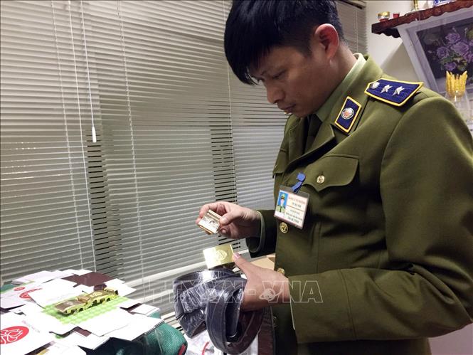 Trong ảnh: Lực lượng QLTT kiểm tra số hàng bị thu giữ. Ảnh: Trần Việt - TTXVN