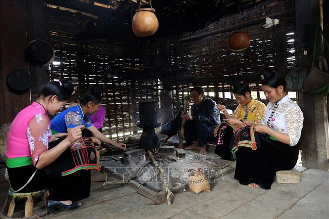 Trong ảnh: Những lúc rảnh rỗi, phụ nữ Thái thường hay thêu thùa họa tiết hoa văn để may trang phục. Ảnh: Phan Tuấn Anh - TTXVN