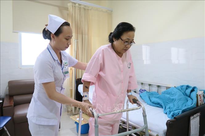Trong ảnh: Bệnh nhân Trần Thị Kim Anh (bị gãy chân) đang được hỗ trợ vận động tại Bệnh viện Sài Gòn ITO Phú Nhuận. Ảnh: Đinh Hằng - TTXVN
