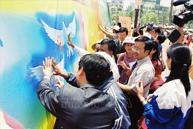 Trong ảnh: Đại biểu thanh niên Việt-Trung tham gia “in dấu tay”, biểu thị tình đoàn kết, hữu nghị tại Lễ hội văn hoá dân tộc thanh niên Châu Văn Sơn, tỉnh Vân Nam (Trung Quốc), ngày 13/6/2004. Ảnh: TTXVN