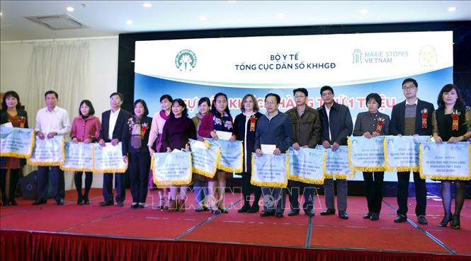 Trong ảnh: Đại diện lãnh đạo Tổng cục Dân số - Kế hoạch hóa gia đình (Bộ Y tế) trao Cờ thi đua cho các cá nhân, tập thể đã hoàn thành công tác phát triển mạng lưới và đào tạo nhân lực y tế. Ảnh: Dương Ngọc – TTXVN