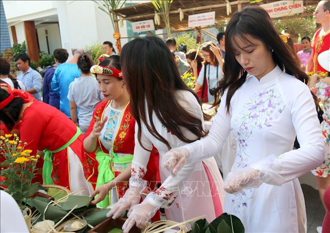 Trong ảnh: Các cô gái đến từ Hàn Quốc thích thú với việc gói bánh chưng Tết Việt. Nguyễn Thanh - TTXVN