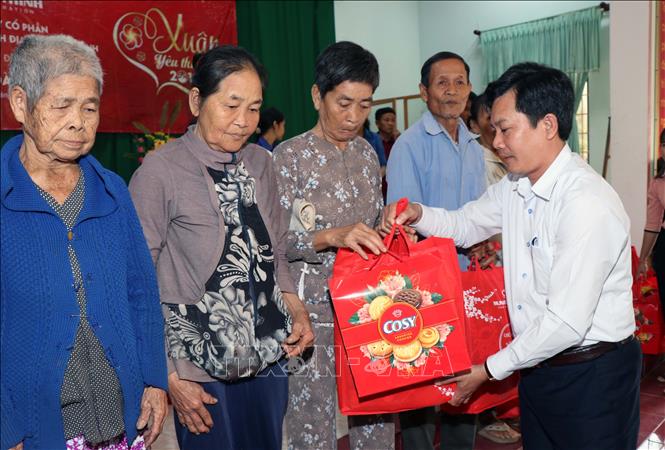 Chủ tịch UBND huyện Hoài Nhơn Cao Thanh Thương tặng quà cho người nghèo xã Hoài Hảo. Ảnh: Phạm Kha-TTXVN