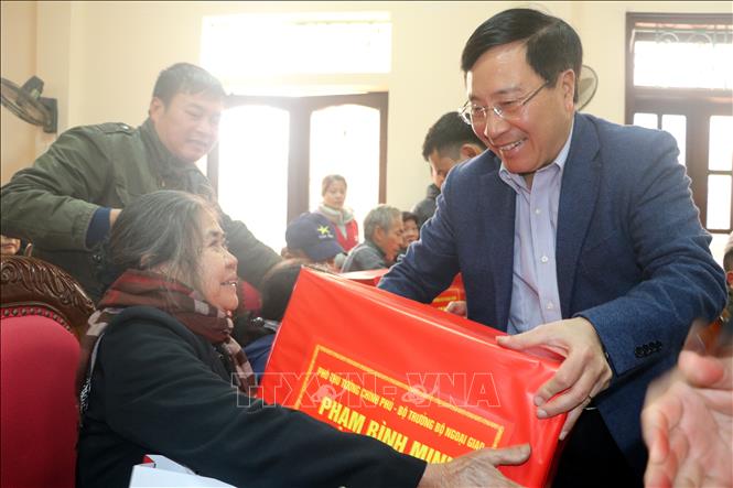 Photo: Deputy Prime Minister and Foreign Minister Pham Binh Minh presents Tet gifts to policy beneficiaries in My Loc district. VNA Photo: Văn Đạt