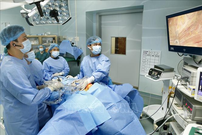 Trong ảnh: Thạc sĩ, bác sĩ Phan Hoàng Hiệp (trái) trực tiếp phẫu thuật nội soi tuyến giáp một lỗ cùng kíp mổ (ảnh chụp sáng 23/1/2019). Ảnh: Dương Ngọc - TTXVN