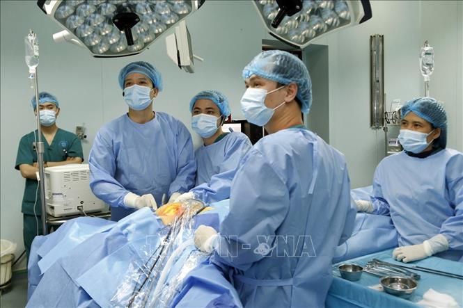 Trong ảnh: Thạc sĩ, bác sĩ Phan Hoàng Hiệp (trái) chẩn đoán đường mổ trước phẫu thuật nội soi tuyến giáp một lỗ (ảnh chụp sáng 23/1/2019). Ảnh: Dương Ngọc - TTXVN