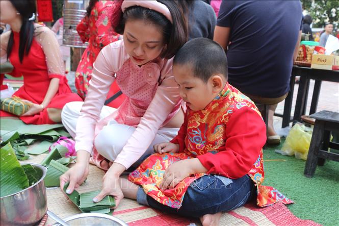 Trong ảnh: Hướng dẫn trẻ gói bánh chưng ở trường Mầm non Hoa Sen, thành phố Vinh. Ảnh: Bích Huệ - TTXVN
