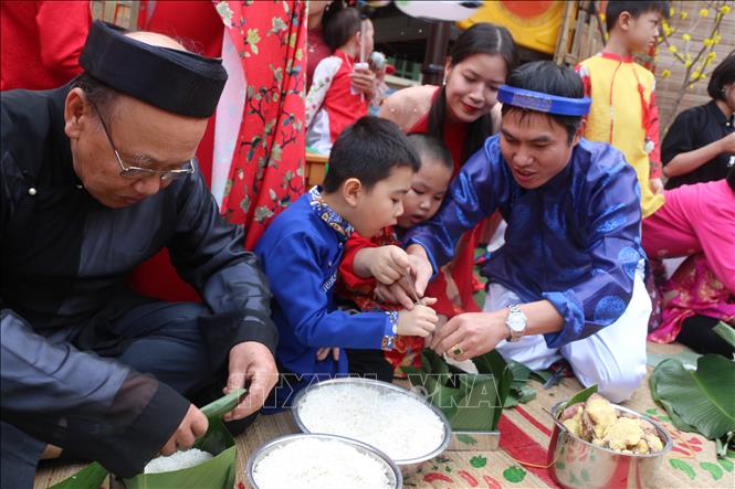 Trong ảnh: Hướng dẫn trẻ gói bánh chưng ở trường Mầm non Hoa Sen, thành phố Vinh. Ảnh: Bích Huệ - TTXVN