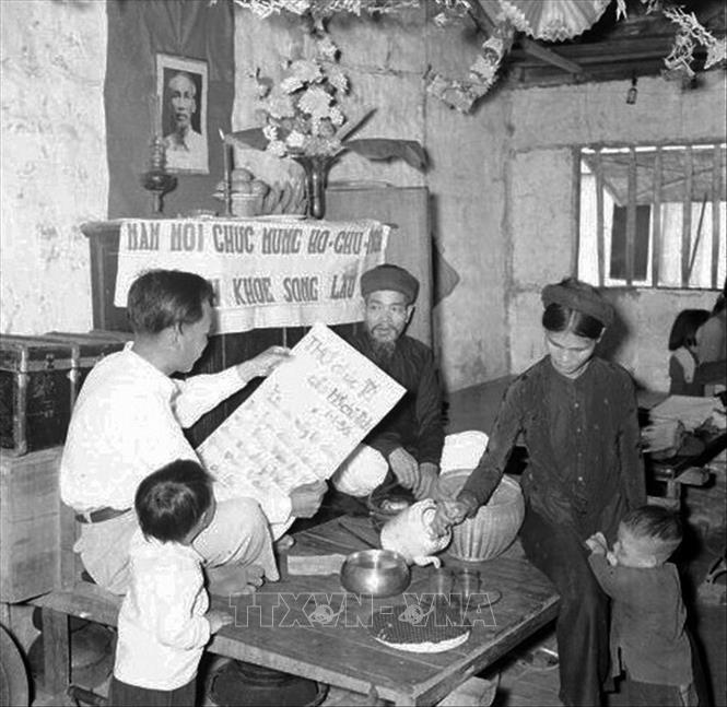 Trong ảnh: Sáng mồng một Tết, cả gia đình ngồi trước bàn thờ Tổ quốc nghe đọc thư chúc Tết của Hồ Chủ tịch trong dịp đầu năm. Ảnh: TTXVN