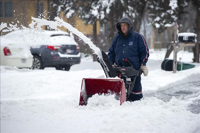 Trong ảnh: Người dân dọn tuyết trên đường phố ở Saugus, Massachusetts, Mỹ, ngày 20/1/2019. Ảnh: AFP/ TTXVN