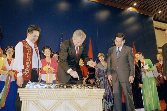 Trong ảnh: Tổng thống Hoa Kỳ George W.Bush chơi đàn bầu – nhạc cụ truyền thống của Việt Nam trong bữa tiệc chiêu đãi do Chủ tịch nước Nguyễn Minh Triết tổ chức tại Trung tâm Hội nghị Quốc tế (Hà Nội), trong chuyến thăm chính thức Việt Nam từ ngày 17-20/11/2006. Ảnh: Nguyễn Khang - TTXVN

