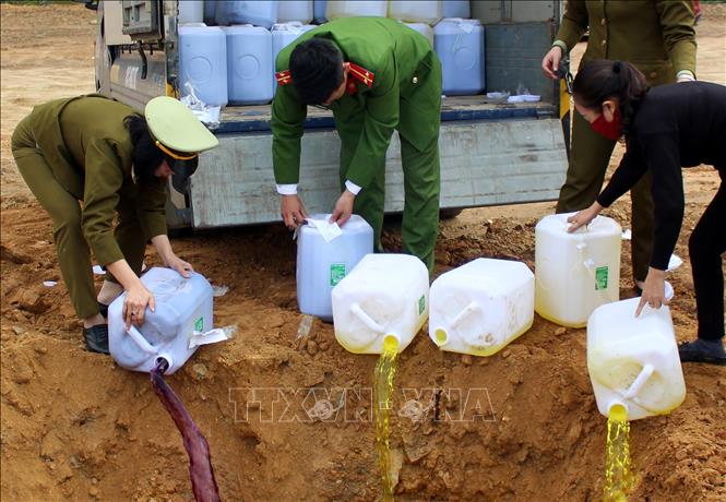 Trong ảnh: Tiêu hủy rượu ngô bao tử không rõ nguồn gốc. Ảnh: Quốc Khánh - TTXVN