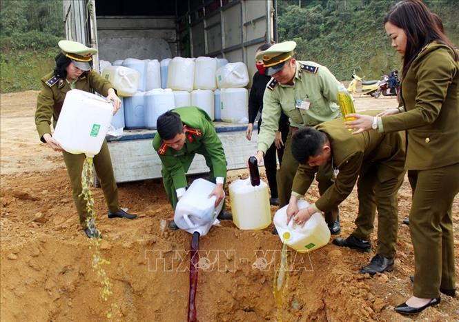 Trong ảnh: Tiêu hủy rượu ngô bao tử không rõ nguồn gốc. Ảnh: Quốc Khánh - TTXVN