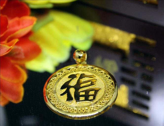 Trong ảnh: Mặt dây chuyền mang chữ Phước, sáng tác mới của ghệ nhân ưu tú nghề kim hoàn xứ Huế Trần Duy Mong. Ảnh: Quốc Việt - TTXVN