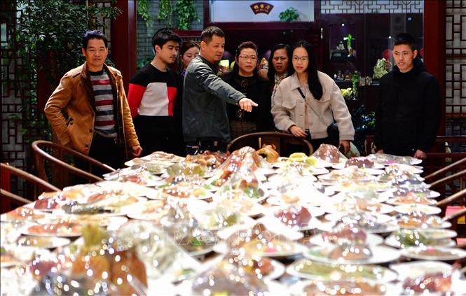 Trong ảnh: Khách mời ngắm các món ăn tại bàn đại tiệc trăm món bằng đá quý trưng bày tại Phúc Châu, Trung Quốc. Ảnh: THX/TTXVN