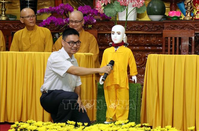 Trong ảnh: Tiến sỹ, Kỹ sư Nguyễn Bá Hải hướng dẫn người dân đặt câu hỏi về Phật pháp cho chú tiểu Giác Ngộ 4.0. Ảnh: Xuân Khu-TTXVN