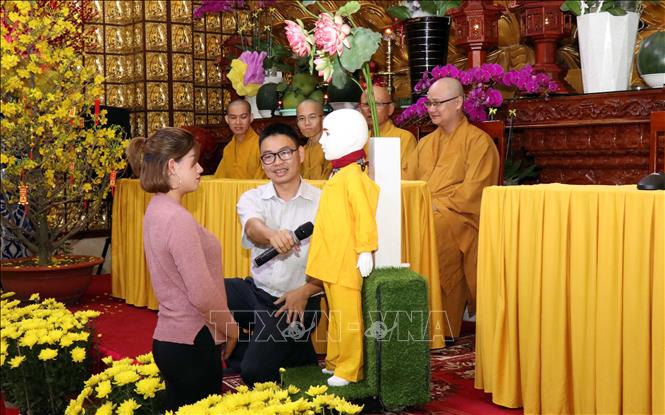 Trong ảnh: Tiến sỹ, Kỹ sư Nguyễn Bá Hải hướng dẫn người dân đặt câu hỏi về Phật pháp cho chú tiểu Giác Ngộ 4.0. Ảnh: Xuân Khu-TTXVN
