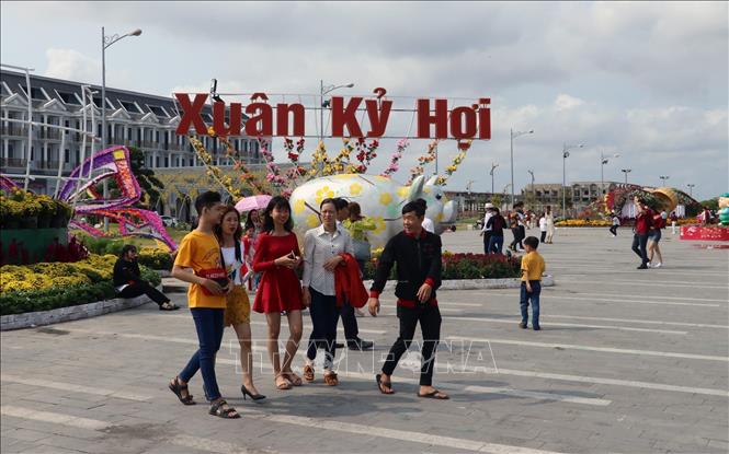 Trong ảnh: Du khách trên đường hoa xuân Khu đô thị Phú Cường, TP. Rạch Giá (Kiên Giang). Ảnh: Lê Huy Hải - TTXVN