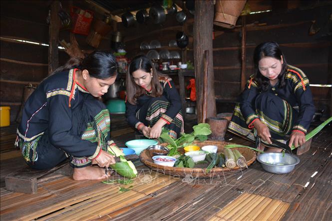 Các cô gái Ê Đê mỗi người một việc để chuẩn bị nguyên liệu nấu món canh bột lá yao. Ảnh: Hoài Thu – TTXVN.