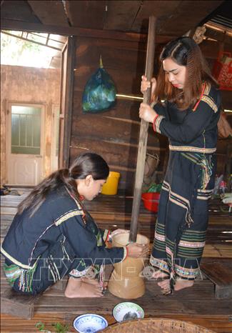 Hai cô gái Ê Đê giã hỗn hợp lá yao và bột gạo, hai nguyên liệu quan trọng nhất, không thể thay thế của món canh bột lá yao. Ảnh: Hoài Thu – TTXVN.