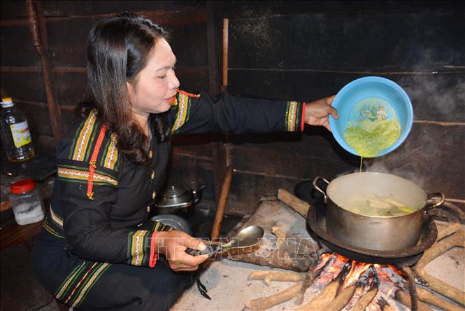 Chắt nước từ hỗn hợp lá yao và bột gạo vào nồi canh sau khi đã được giã đều, mịn. Ảnh: Hoài Thu – TTXVN.