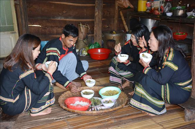 Một gia đình người Ê Đê quây quần bên bữa ăn với các món ăn truyền thống. Ảnh: Hoài Thu – TTXVN.