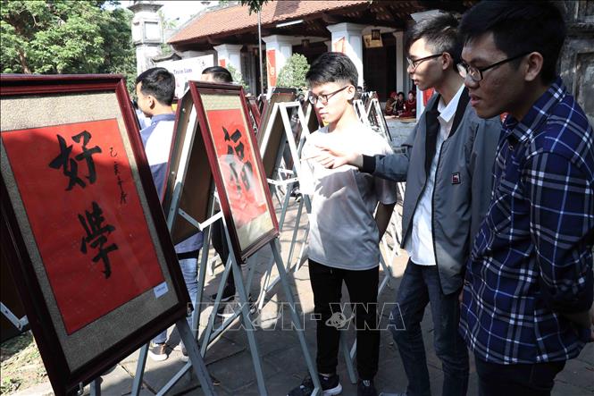 Trong ảnh: Các em học sinh tham quan các mẫu chữ Hán. Ảnh: Đinh Tuấn - TTXVN 