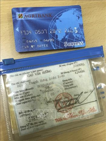 Trong ảnh: Thẻ ATM và Đăng ký xe của nạn nhân được cơ quan điều tra thu giữ trong cặp của Vương Văn Hùng. Ảnh: TTXVN phát