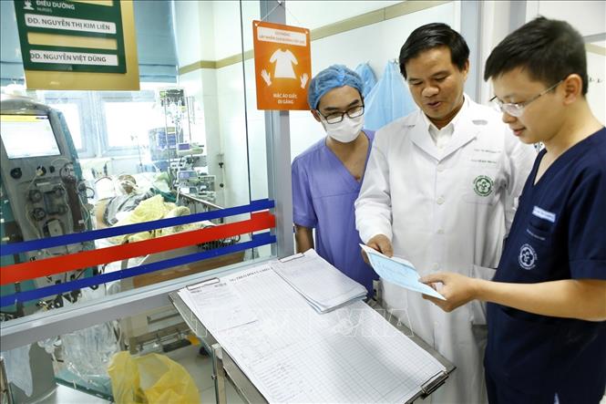 Trong ảnh: PGS Đào Xuân Cơ (giữa) cùng các bác sĩ Khoa Hồi sức tích cực – Bệnh viện Bạch Mai hội chẩn ca bệnh cúm A/H1N1 cho bệnh nhân 61 tuổi (nam) đang nguy kịch. Ảnh: Dương Ngọc – TTXVN