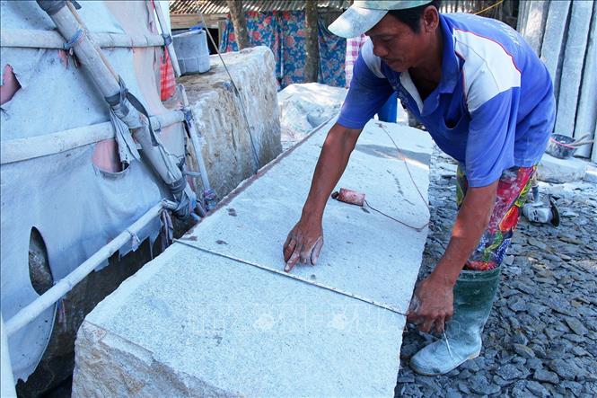 Trong ảnh: Đo kích thước để định hình khổ của cây đá. Ảnh: Hồng Đạt - TTXVN

