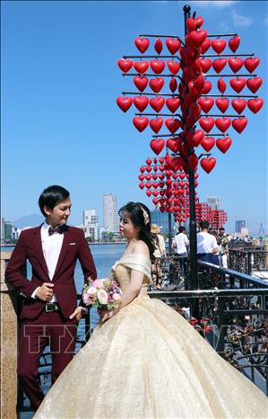 Trong ảnh: Cùng nhau ghi lại những hình ảnh đẹp nhất trên cầu Tình yêu trong ngày 14/2. Ảnh: Trần Lê Lâm - TTXVN