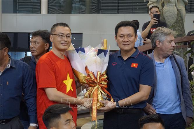 Photo: Vietnamese Ambassador to Cambodia Vu Quang Minh (in red) offers flowers to the U22 team's coach Nguyen Quoc Tuan at the Phnom Penh Airport. VNA Photo