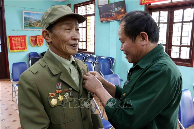 Trong ảnh: Các cựu binh Biên phòng thành phố Lai Châu giúp nhau gắn huân chương lên ngực trước khi vào dự buổi gặp mặt. Ảnh: Công Tuyên-TTXVN