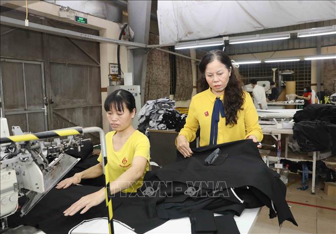 Trong ảnh: Chị Ninh Thị Ty (bên phải) kiểm tra chất lượng sản phẩm tại Công ty Cổ phần may Hồ Gươm trước khi xuất khẩu. Ảnh: Phương Hoa - TTXVN