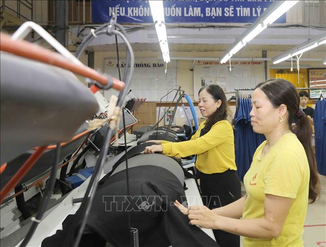 Trong ảnh: Chị Ninh Thị Ty (bên trái) kiểm tra chất lượng vải may tại Công ty Cổ phần may Hồ Gươm. Ảnh: Phương Hoa - TTXVN