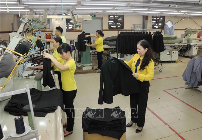 Trong ảnh: Bà Ninh Thị Ty (bên phải) kiểm tra chất lượng sản phẩm tại Công ty Cổ phần may Hồ Gươm. Ảnh: Phương Hoa - TTXVN
