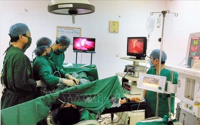 Trong ảnh: Bác sĩ chuyên khoa II Trần Văn Chung (trái) mặc dù bận rộn với công tác quản lý nhưng hàng ngày vẫn trực tiếp phẫu thuật sản khoa, phụ khoa cho bệnh nhân. Ảnh: Bệnh viện cung cấp –TTXVN phát