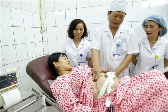 Trong ảnh: Bác sĩ chuyên khoa II Trần Văn Chung mặc dù bận rộn với công tác quản lý nhưng vẫn trực tiếp đào tạo nâng cao năng lực cho các bác sĩ trong việc tiên lượng, đánh giá tình trạng sản phụ để xử trí an toàn chuyên môn. Ảnh: Dương Ngọc – TTXVN