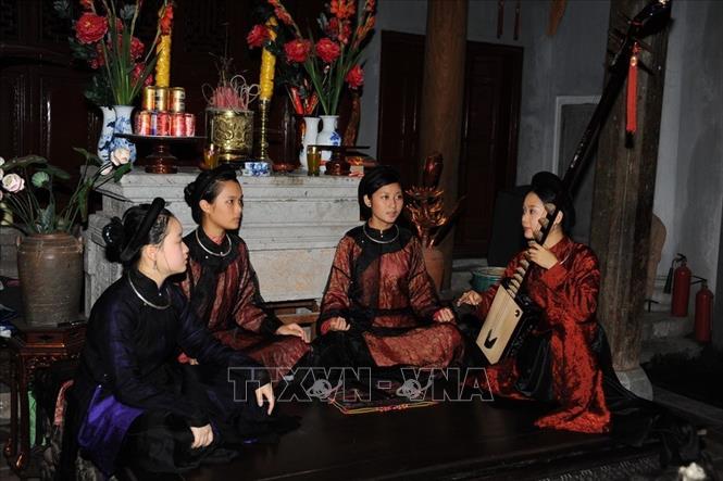 Trong ảnh: Đào nương Phạm Thị Huệ (bên phải) - Chủ nhiệm Câu lạc bộ Ca trù Thăng Long, hướng dẫn hội viên trẻ cách thể hiện những làn điệu hát hay tại Giáo phường Thăng Long. Ảnh: TTXVN