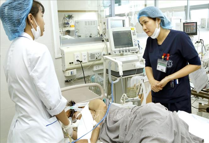 Trong ảnh: Điều dưỡng trưởng Hoàng Minh Hoàn hướng dẫn đồng nghiệp chăm sóc điều trị bệnh nhân. Ảnh: Dương Ngọc – TTXVN