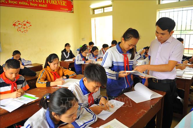 Trong ảnh: Giáo viên trường THCS Đồng Phong hướng dẫn học sinh giải toán song ngữ Việt - Anh. Ảnh: Minh Đức - TTXVN
