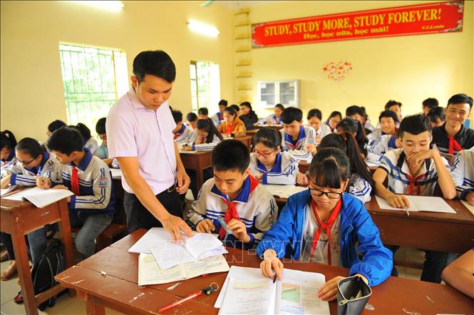 Trong ảnh: Giáo viên trường THCS Đồng Phong hướng dẫn học sinh giải toán song ngữ Việt - Anh. Ảnh: Minh Đức - TTXVN