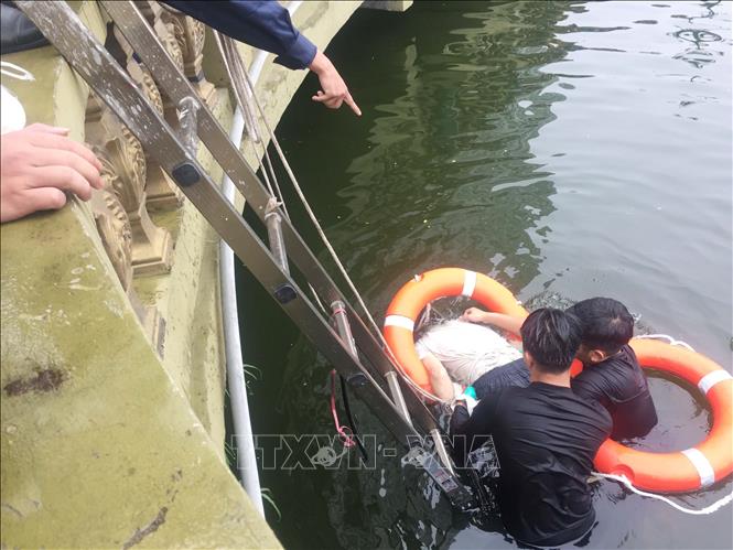 Trong ảnh: Lực lượng cứu hộ đang vớt thi thể nạn nhân lên bờ. Ảnh: Nguyễn Oanh-TTXVN