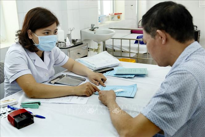 Trong ảnh: Hơn 95% dân số xã Tân Lập, huyện Đan Phượng được lập hồ sơ chăm sóc sức khỏe ban đầu, quản lý điều trị các bệnh không lây nhiễm và cấp thuốc Bảo hiểm Y tế tại trạm y tế thay vì trước đó phải lên tuyến trên. Ảnh: Dương Ngọc - TTXVN