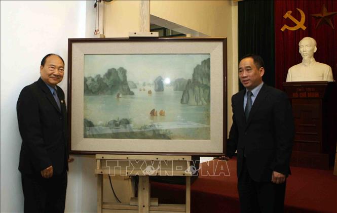 Trong ảnh: Ông Nguyễn Anh Minh (bên phải), Giám đốc Bảo tàng Mỹ thuật Việt Nam bàn giao tác phẩm “Vịnh Hạ Long” cho đại diện bảo tàng Kaysone Phomvihane. Ảnh: Thanh Tùng-TTXVN