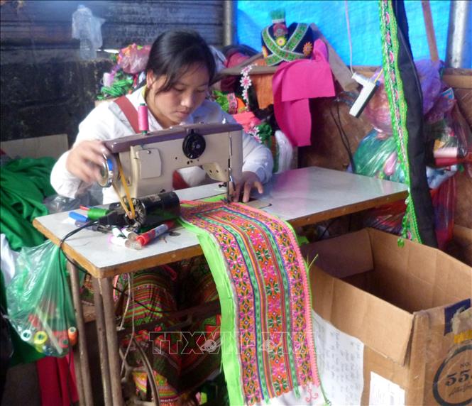 Trong ảnh: Chị Tráng Thúy Màu, thôn Mỹ Hoa, xã Mỹ Bằng may trang phục truyền thống của người Mông để bán cho người dân. Ảnh: Quang Đán - TTXVN